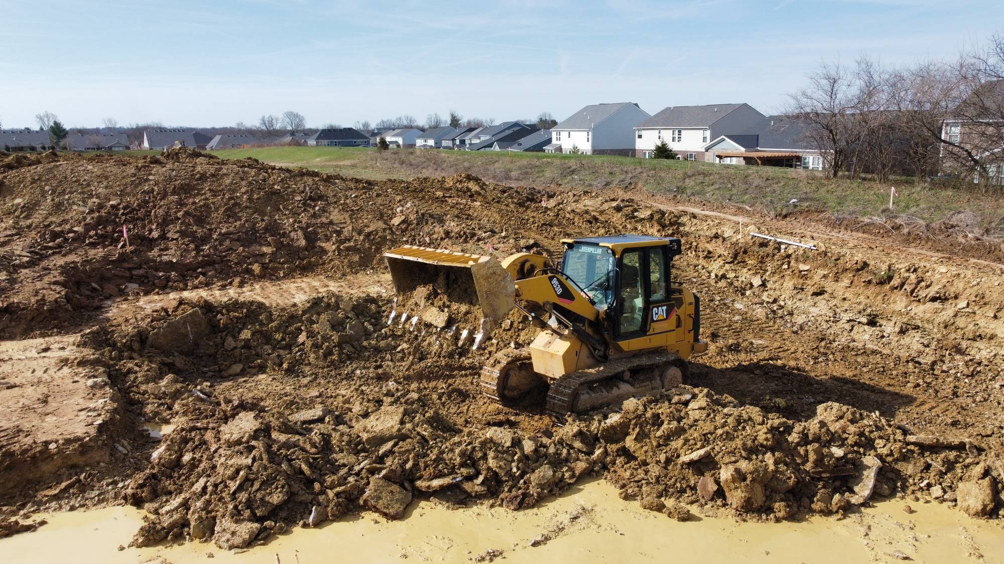 CAT 953D track loader mass-grading a lot for Solid Rock Excavating