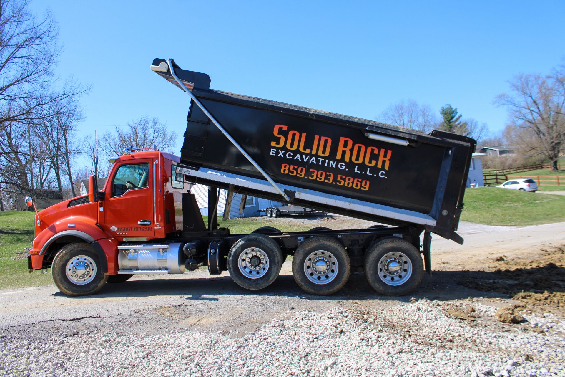Solid Rock Excavating tri-axle dump truck unloading material on a Northern Kentucky job