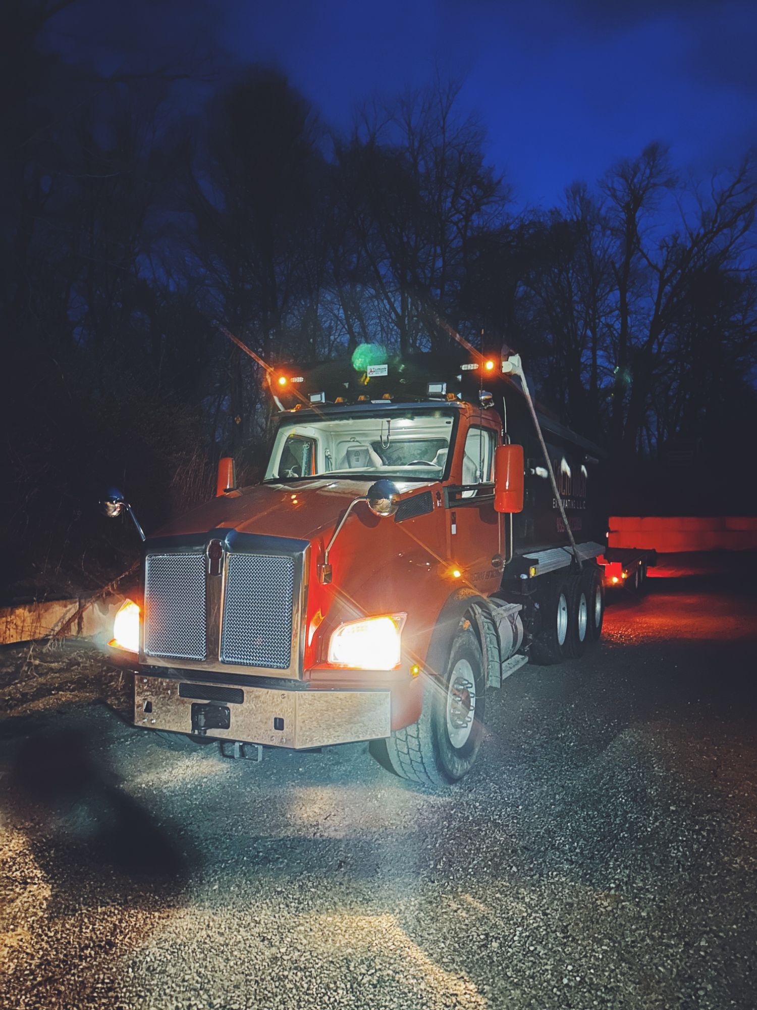 Solid Rock Excavating Kenworth dump truck at dusk on a job site