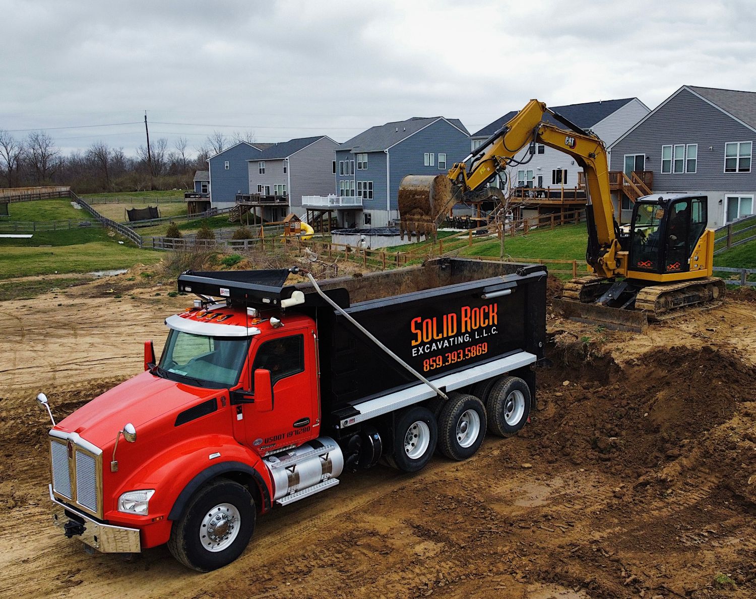 Solid Rock Excavating dump truck being loaded by a CAT excavator on a Northern Kentucky job site